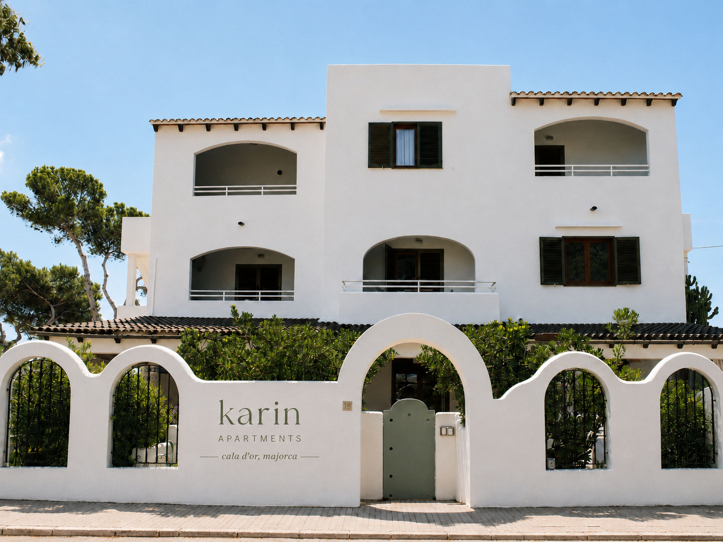 Whitewashed Mediterranean apartment building with terracotta trim